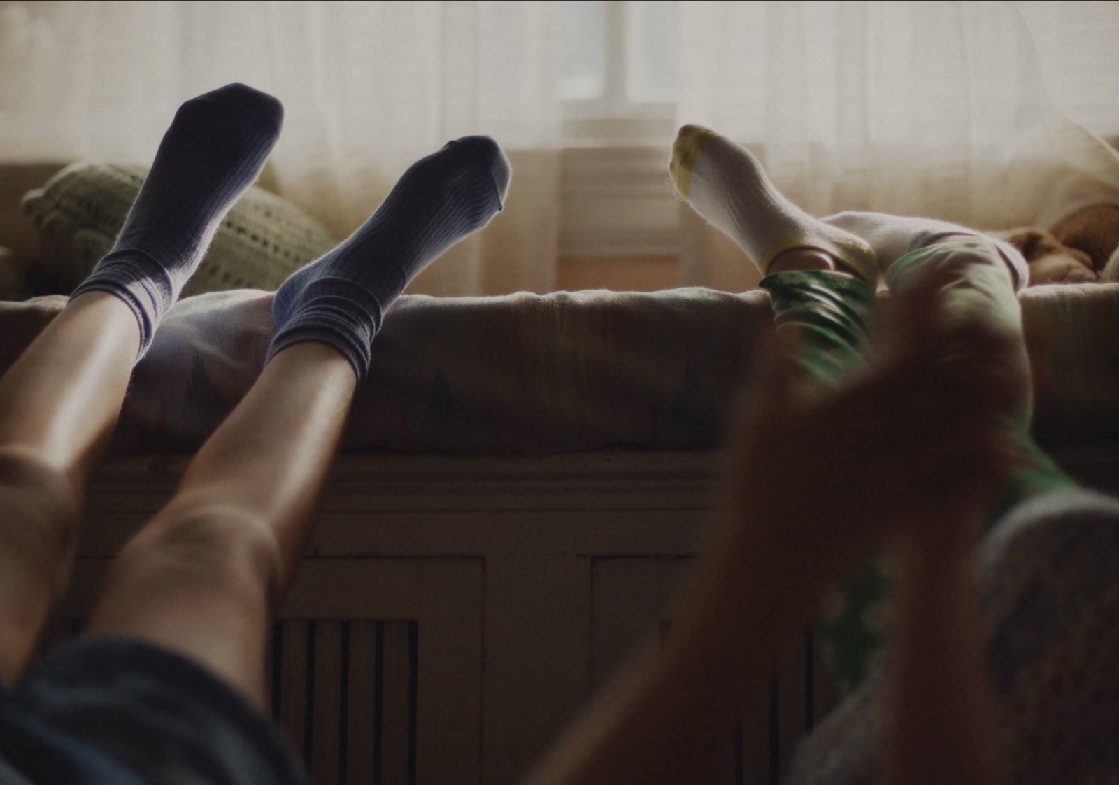 Pieds en chaussettes de deux amoureux devant une fenêtre